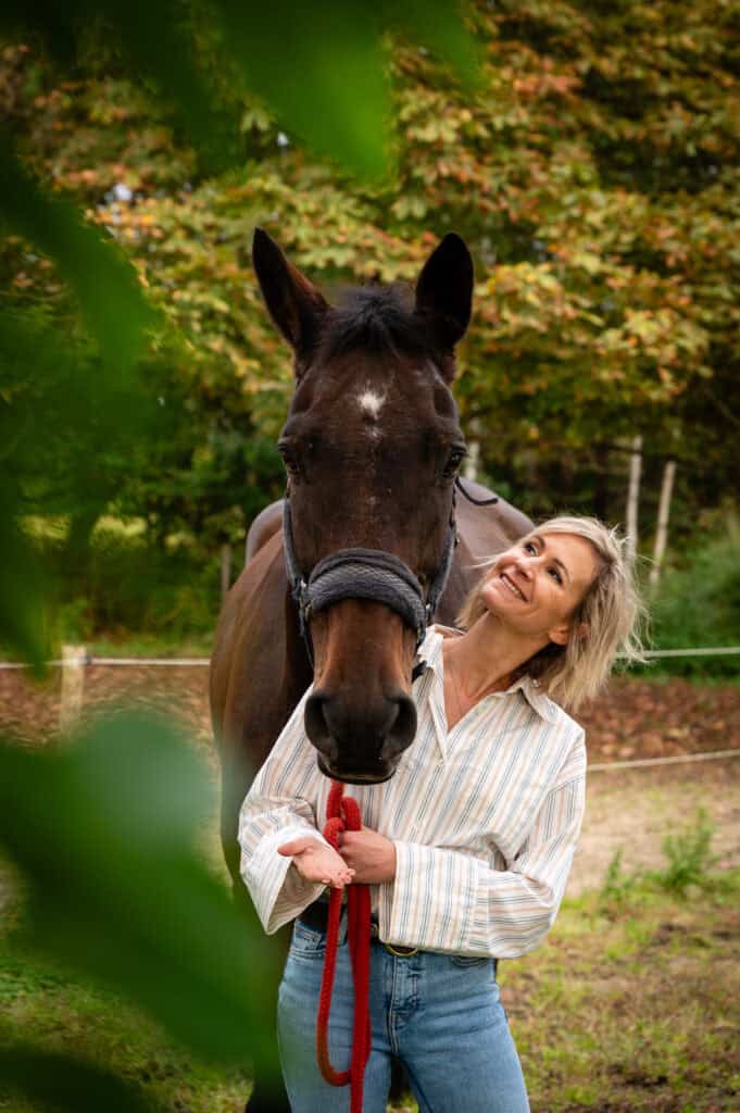 Gezellige vrouwenfoto met een vrouw en haar paard in de natuur, geschikt voor paardrijden, dierenliefde en outdoor activiteiten.